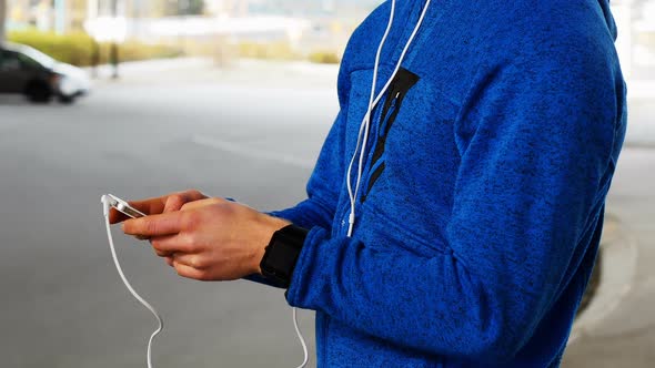 Young man with headphones listening to music on mobile phone, 4K 4k