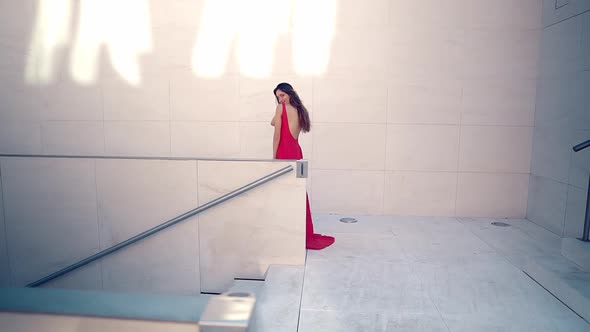 Beautiful Woman in Red Elegant Dress. Urban White Background