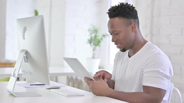 Hardworking Casual African Man Using Tablet in Office