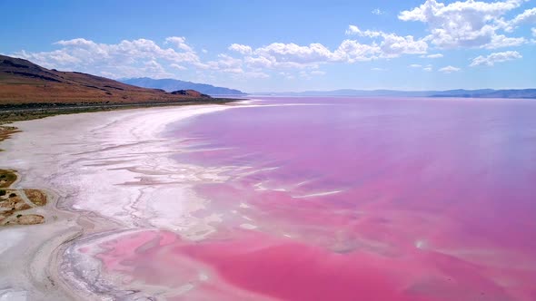 Aerial view flying along shoreline of pink lake in Utah