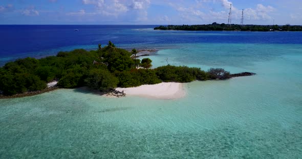 Luxury flying travel shot of a sunshine white sandy paradise beach and aqua blue ocean background in