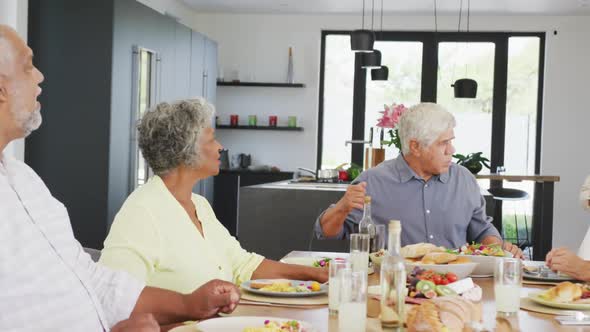 Happy senior diverse people having dinner at retirement home