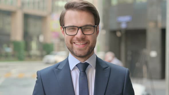 Portrait of Businessman Smiling at Camera while Standing in Street