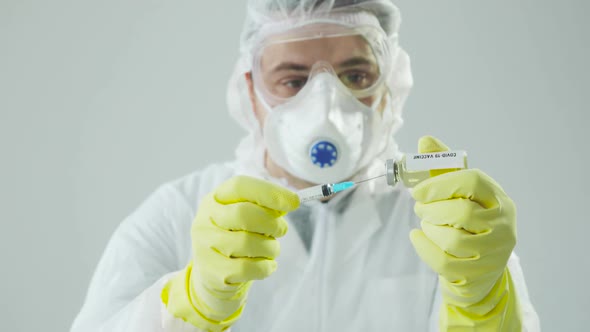 Portrait Doctor Fills Syringe with Coronavirus Vaccine, Preparing for Injection