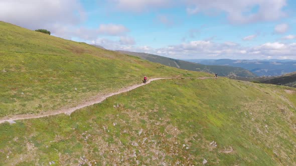 Aerial View of a Traveler with Backpack Climbing Along Mountain Slope. Epic Shot