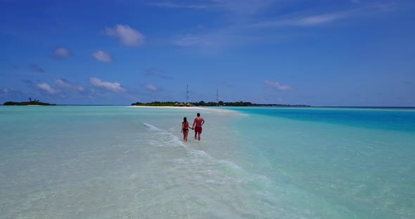 Beautiful boy and girl on romantic honeymoon enjoy life on beach on summer white sandy background