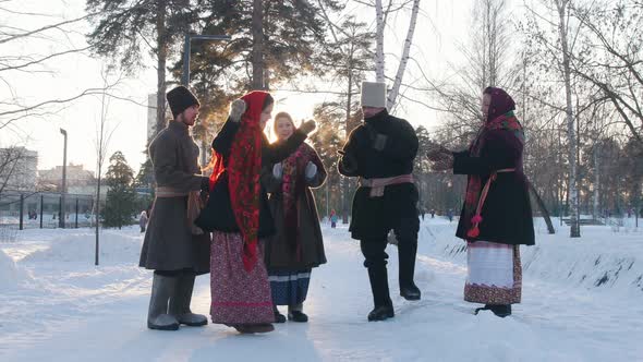 Russian Folk - a Group of People in Traditional Costumes Are Dancing in a Circle and Clappping