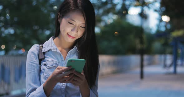 Woman looking at mobile phone in the evening