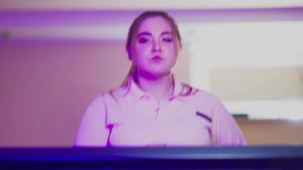 Concentrated Motivated Plump Woman Jogging on Treadmill Looking at Camera and Smiling