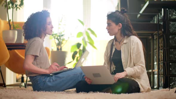 Diverse Multiethnic Couple Sitting on Couch Sofa in Stylish Living Room and Choosing Items Buy