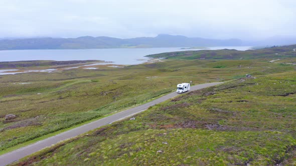 Aerial Drone View of Car Driving on Roads of Scottish Highlands, Scotland, on Road Trip Holiday with