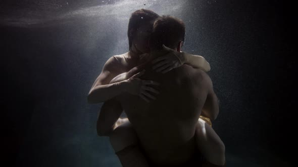 Passionate Embrace of Loving Pair Underwater Young Man and Woman Are Hugging in Depth of Pool