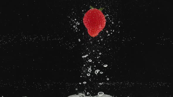 Strawberry Beautiful Falling Into Water in Slow Motion on Black Background