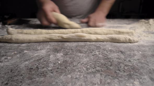 Men's hands hold dough. making raw dough for pizza, rolls or bread.