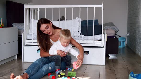 Little Cute Boy with His Mother Play with Toys at Home