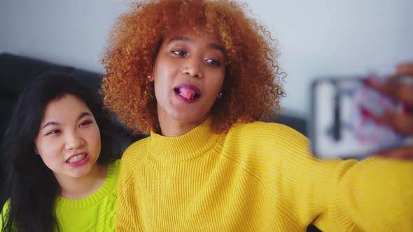 Best Friends Asian and African American Black Woman Taking Selfie Using Smartphone. Funny Faces