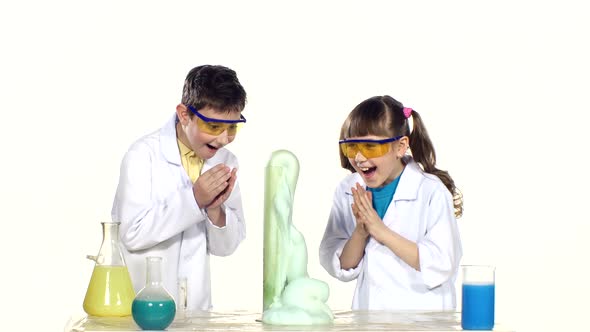 Two Cute Chemist Children Making Interesting and Successful Experiments with Blue Foam Isolated on