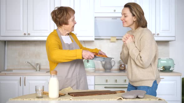 Grandmother And Granddaughter Baking Pastry In The Kitchen Together