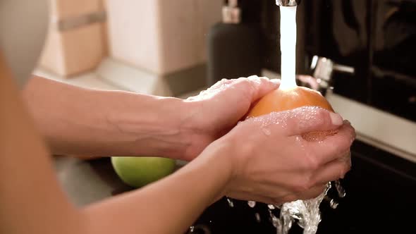 Washing Fruits With Clean Water In Kitchen Closeup