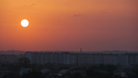 Evening Landscape with Bright Setting Sun Over Distant City High Rise Buildings at Sunset