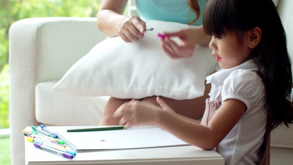 Lovely girl selecting colour pencil for drawing with mother