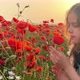Happy girl in a field of blooming red poppies. Leisure in nature. Enjoying 4k - VideoHive Item for Sale