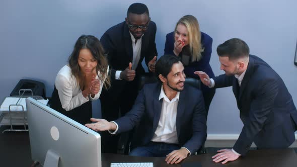 Portrait of Shocked Business Team By the Table Looking at Laptop in Office