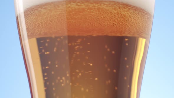 Shot of Fine Bubbles Rising in a Glass of Beer Against a Light Blue Background