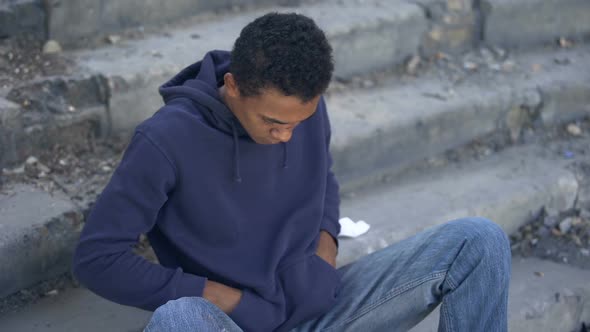 Poor Young Man Counting Money Sitting Alone City Stairs, Low Living Standard