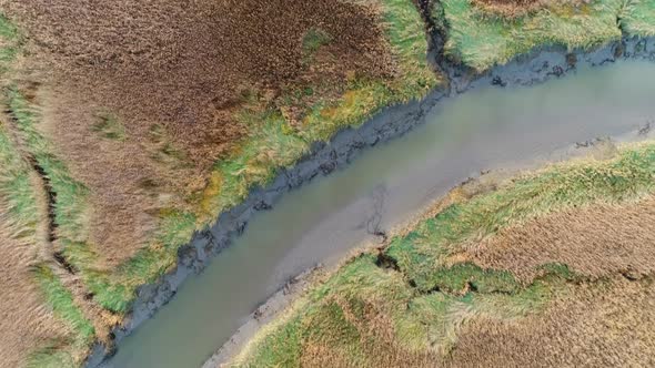 Aerial view of small river crossing wetland during sunset, Netherlands.