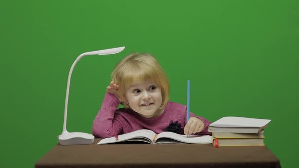 Girl Drawing at the Table. Education Process in Classroom. Chroma Key