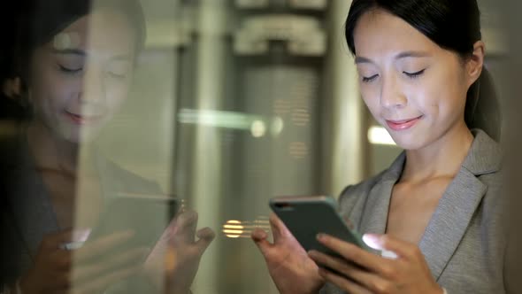 Window reflection of business woman use of smart phone 