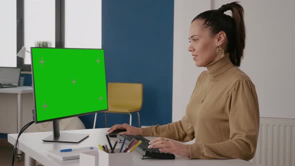 Person Looking at Green Screen on Computer Display in Office