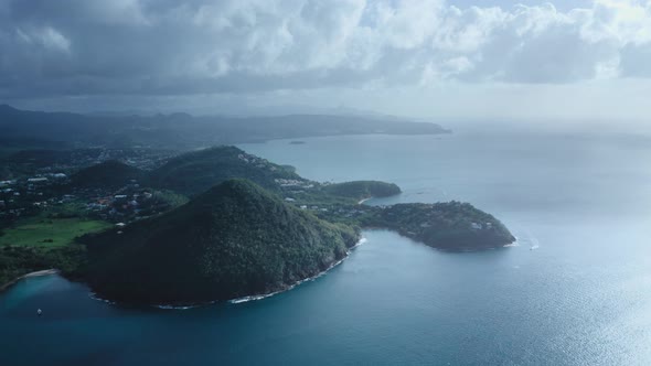 Aerial shot of mountains on the sea coast, city, yacht, clouds (Saint Lucia)