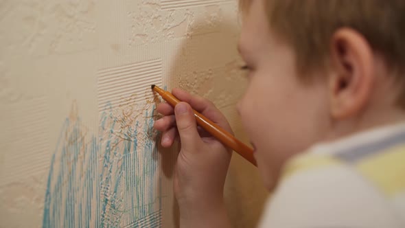 Caucasian Child Boy Sits Near Wall Draws on Wallpaper with Felttip Pen