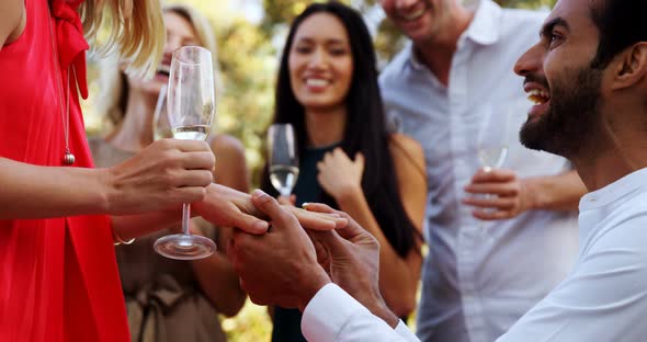 Man putting a ring on a womans finger in balcony