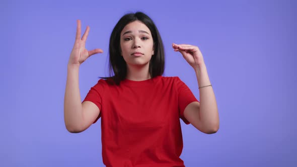 Pretty Woman Showing Blablabla Gesture with Hands Isolated on Violet Background