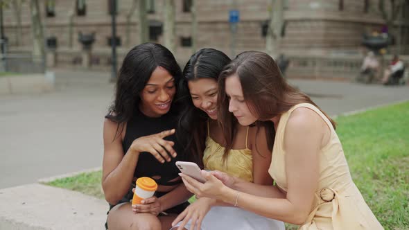 Three Diverse Female Friends Making Selfie on Smartphone Outdoors and Choosing Best Shot