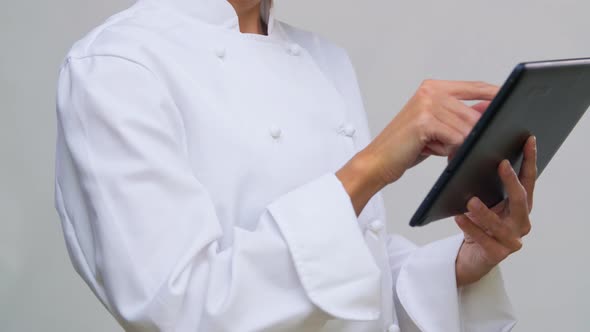 Smiling Female Chef in Toque with Tablet Computer