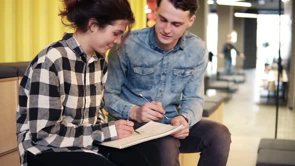 Two Young People Enjoy Their Time Together Drawing Something in Notepad