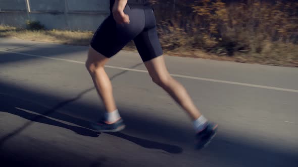 Running Man In Forest At Sunset. Runner Man Fit Athlete Legs Jogging On Trail Ready To Triathlon.