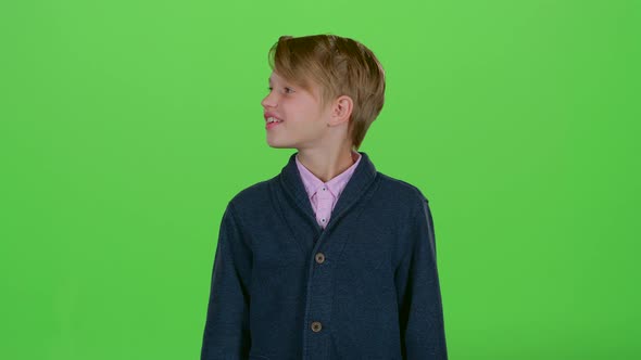 Teenager Looks Around and Then Shows a Credit Card on a Green Screen