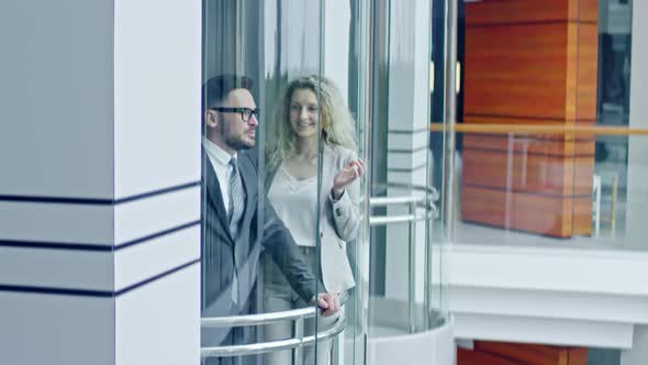 Businesspeople Riding Glass Elevator