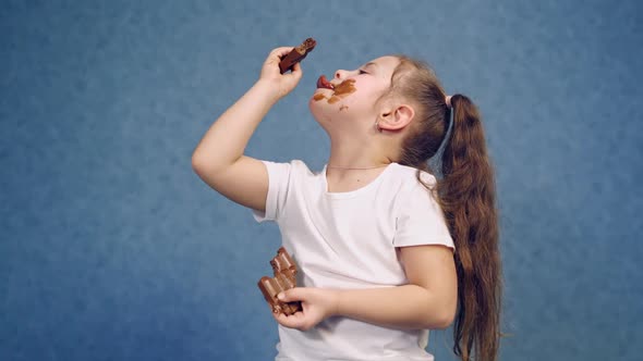 Cute girl licking bars of chocolate indoors. 