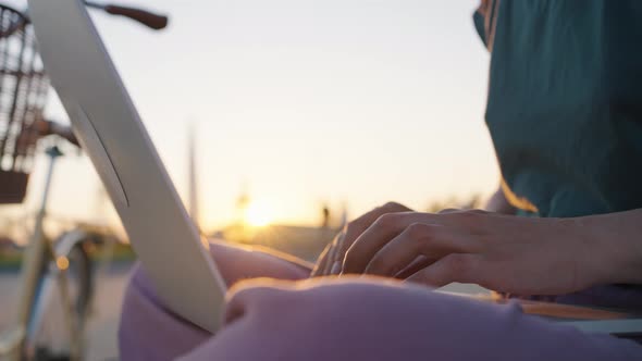 Businesswoman Freelancer Hands Typing on Laptop Keyboard at Sunset in City Park Closeup