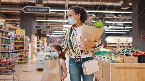 Mother and Daughter Carry Paper Bags Full of Groceries Fruits and Greens