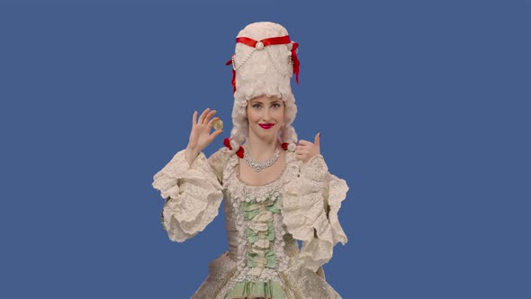 Portrait of Courtier Lady in Vintage Dress and Wig Showing a Bitcoin Coin and Making Thumbs Up