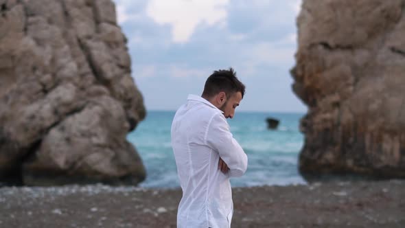 Young Handsome Man Walk Near Windy Sea Side on the Beach Between Rocks. Cyprus. Paphos