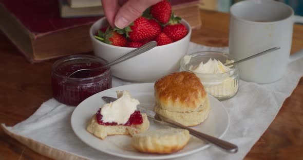 Cornish Scones Cream and Jam with a Bowl of Strawberries. Person Eating Delicious British Food Favou