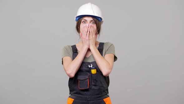 Portrait of Young Woman Builder in Helmet and Jumpsuit Screaming in Excitement and Clenching Fists